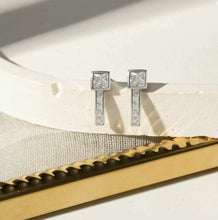 Cargar imagen en el visor de la galería, Pendientes cuadrados rectos con circonita cúbica blanca talla baguette - Plata de ley 925
Este pendiente recto de plata de ley 925 combina una circonita blanca cuadrada central con una hilera vertical de baguettes engastadas en pavé. Un diseño moderno y simétrico que aporta elegancia con discreción.
Una Joya unica Wal Barros Brand.
joyas hipoalergénicas y sin níquel.