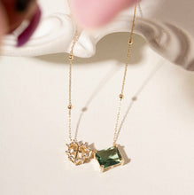 Cargar imagen en el visor de la galería, Collar escapulario con colgantes, cristal verde y colgante sagrado corazón, la pieza crea un aspecto ligero y refinado. El contraste de colores hace que el escapulario sea llamativo, luminoso y lleno de personalidad.
cadena 70 cm - Chapado en oro de 18 quilates.
se puede hacer conjunto con el pendiente. Ventas separadas.