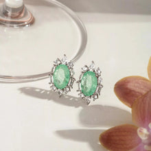 Cargar imagen en el visor de la galería, Este pendiente ovalado, con una fusión de esmeralda colombiana y circonita cúbica blanca, ofrece un look elegante y sofisticado en la medida justa. La piedra central realza el intenso verde con un brillo refinado, mientras que la circonita cúbica blanca ilumina la composición. Con un baño de rodio blanco, es una pieza moderna, delicada y encantadora.