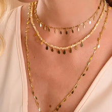 Cargar imagen en el visor de la galería, Collar gargantilla cristales bege con colgantes medalla drops en baño de oro18k. Una semijoya de alta calidad.

collar 32cm + 10cm ajustable.

Antialérgico, no contiene níquel

