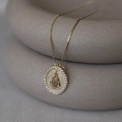 Colar religioso com colgantes de Nuestra Señora de Aparecida, tachonado de circonitas blancas en baño de oro18k o baño de rodio.

gola 45cm + 5cm ajustável