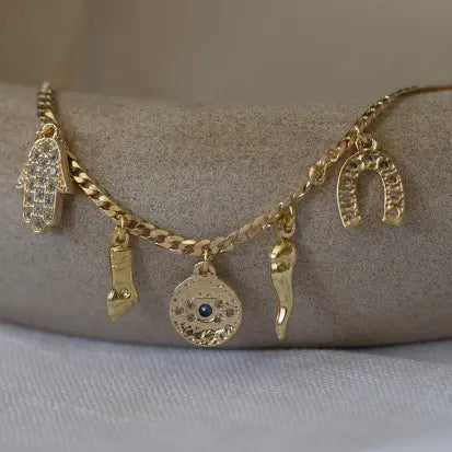 Collar Gargantilla cadena con 5 colgantes de proteción con circonitas cravejadas como un ojo turco, Hamsa, figa en baño de oro 18k.