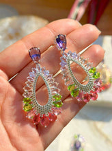 Cargar imagen en el visor de la galería, Pendiente largo gota ametista con cristales coloridos en baño de rodio.

Hipoalergénico y sin niquel.

1 ano de garantia en su baño.
