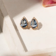 Cargar imagen en el visor de la galería, Pendiente Gotas cristal London Blue con circonitas blancas, Chapado en oro de 18 quilates.

se puede hacer conjunto con el collar escapulario. Ventas separadas.

El pendiente en forma de lágrima es el accesorio perfecto para darle un toque especial a cualquier conjunto. El contraste entre el azul intenso del London Blue y el brillo dorado crea un look sofisticado y con mucho estilo, mientras que la circonita cúbica blanca añade aún más brillo a la pieza. Elegante, moderno y con mucha personalidad.
